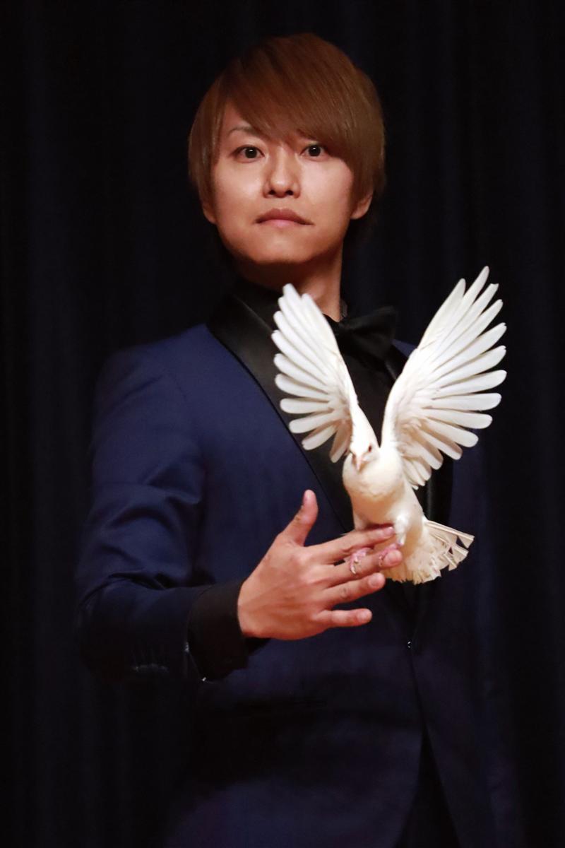白い鳩を抱くマジシャン